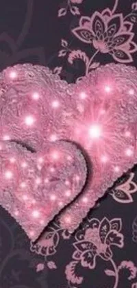 This live phone wallpaper features two adorable pink hearts resting on a wooden table with a blurred picture in the background