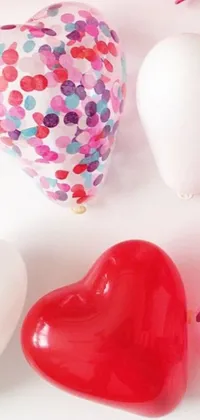 Looking for a charming live wallpaper for your phone? Check out this design featuring heart-shaped balloons with confetti sprinkles! With a white and red color scheme, this playful wallpaper is sure to brighten up your screen