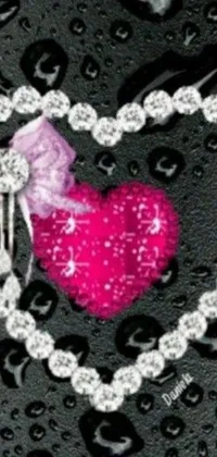 This phone live wallpaper depicts a lovely pink heart with a bow, set against a bold black background