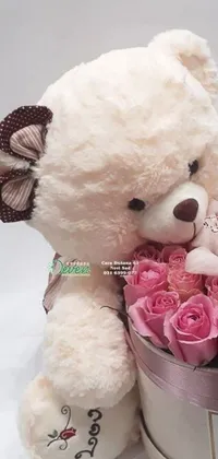 This live wallpaper for your phone features a charming white teddy bear holding a beautiful bouquet of pink roses