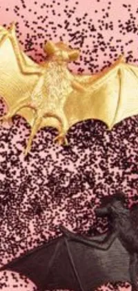 This phone live wallpaper displays a close-up of a bat on a pink surface, surrounded by glitter, gold, and black metal