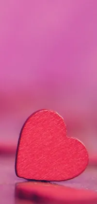 This live wallpaper features a shining red heart on a wooden table, perfect for adding a romantic touch to your iPhone background