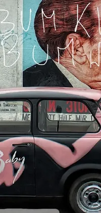 This phone live wallpaper is a stunning image of a black and pink car parked in front of a building