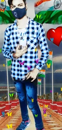This lively phone wallpaper features a full-body portrait of a smiling young man wearing a face mask standing in front of colorful flags