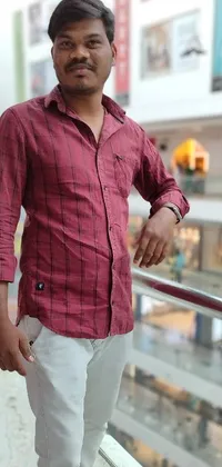 This phone live wallpaper showcases an attractive man dressed in a red elegant shirt, standing next to a mall railing