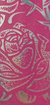 This phone live wallpaper features an intricately etched metal plate with a fuchsia rose at the center