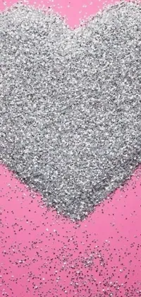 This phone live wallpaper features a stunning heart made out of silver glitter on a soft pink background