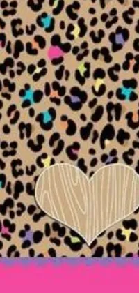 This phone live wallpaper features a vibrant leopard print notebook with a heart design on a wooden background