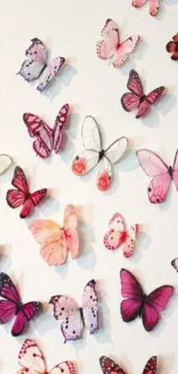 This lovely live wallpaper features a white table filled with pink and purple butterflies against a white background with pink and purple flowers and twinkling fairy lights