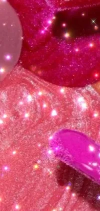 This phone live wallpaper depicts dynamic digital art featuring makeup brushes and glitter over a candy-themed pink backdrop
