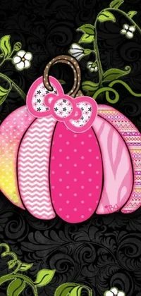 This lively phone live wallpaper showcases a pink pumpkin perched on a black background, complete with silicone patch designs that lend depth and delightful details such as bows, Hello Kitty motif, and playful paisley patterns