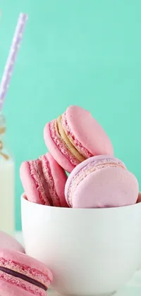 This live wallpaper for the phone features a charming image of sweet macarons on a white plate next to a glass of milk