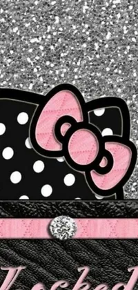 This phone live wallpaper depicts a cute Hello Kitty character sitting atop a trendy purse in a digital rendering