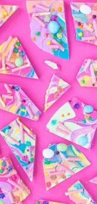 This live wallpaper is a delightful and whimsical design featuring candy bark pieces on a pink background