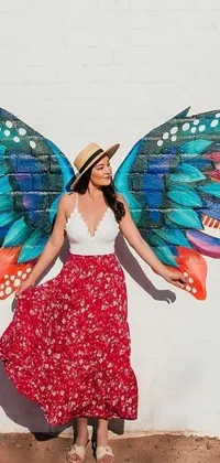 This stunning live wallpaper features a colorful and beautiful portrayal of a woman standing before a wall with painted wings