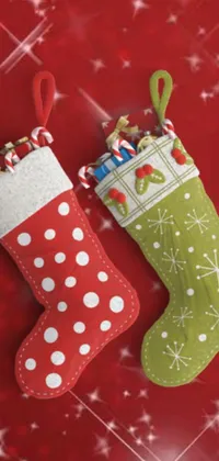 This live wallpaper features two Christmas stockings hanging on a red background