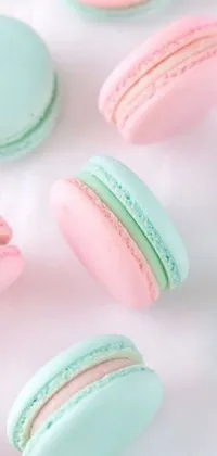 This pastelle wallpaper features a bunch of macarons artfully arranged on a table