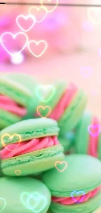 This phone live wallpaper showcases a plate of delicious colorful macarons arranged on a table against a green and pink gradient background