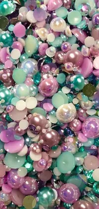 This phone live wallpaper features a colorful pile of green, pink, and purple beads with a pastel aesthetic