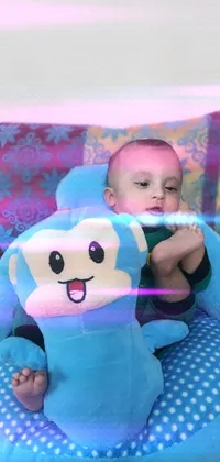 This live wallpaper depicts a cheerful baby sitting in a blue outfit with a stuffed animal monkey, giving a thumbs up sign