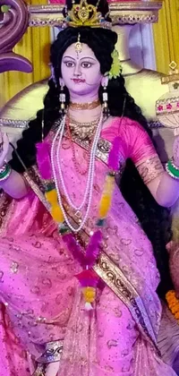 This stunning live wallpaper features a beautifully crafted statue of a woman dressed in a vibrant pink traditional garb