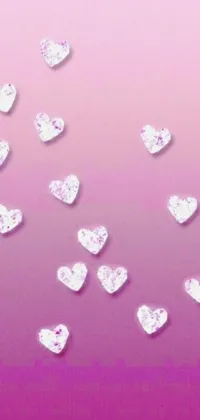 This phone live wallpaper features a collection of pink diamond adorned hearts floating in the sky