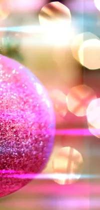 Looking for a beautiful and festive live wallpaper for your phone? Check out this stunning design, featuring a pink ornament hanging from a Christmas tree