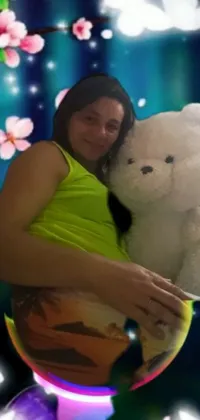 This live phone wallpaper features a white teddy bear hugged by a woman with a glowing pregnant belly image adjacent