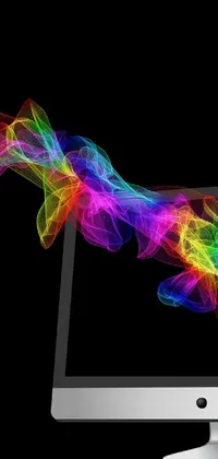 This live wallpaper is an artistic creation of a computer monitor on a desk, featuring x-ray melting colors, particle waves, and rainbow smoke