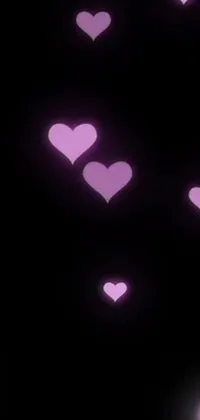 This live wallpaper features a beautiful array of pink hearts delicately floating in the air amidst a dark purple backdrop