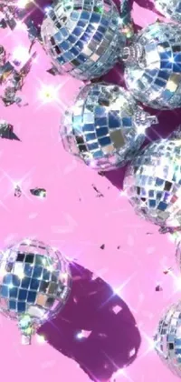 This phone live wallpaper is a dazzling digital art that features a middle close up of a bunch of disco balls sitting on a pink surface