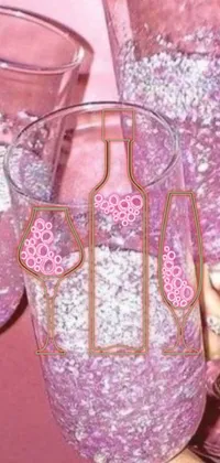 This phone live wallpaper features a close-up of a hand holding a wine glass against a pink background