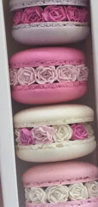 This live wallpaper features a realistic close-up of a box of macarons with a romantic background of roses