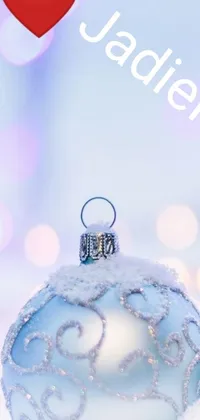 This Christmas-themed phone live wallpaper showcases a festive scene with two ornaments resting on a snowy ground