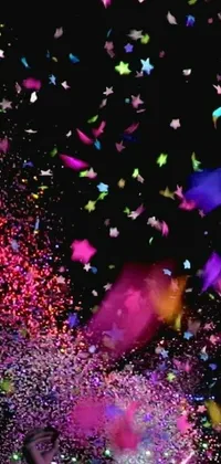 Experience the vibrant energy of a group of people standing on a confetti-strewn stage with this stunning live wallpaper