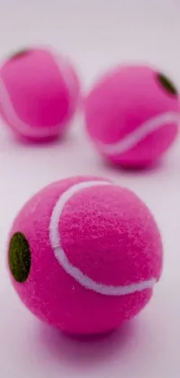 This live phone wallpaper features an image of pink tennis balls on a white surface, captured by Josef Dande
