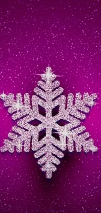 This phone live wallpaper features a close-up view of a glittery magenta snowflake on a vibrant purple background