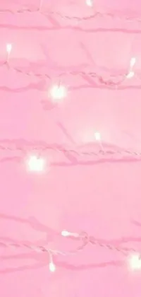 Looking for a striking live wallpaper for your phone? Look no further than this stunning option, featuring a vibrant pink wall, pretty white lights, and a central image that's sure to catch your eye