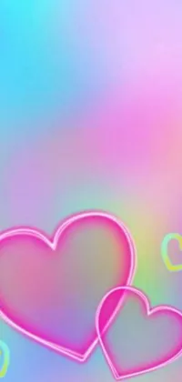 This phone live wallpaper features a pair of pink hearts on a rainbow background with glittery particles floating around them