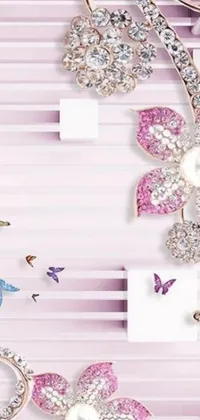 This stunning phone live wallpaper showcases a beautiful arrangement of brooches on a pink, flowery background