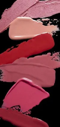 This live wallpaper showcases four shades of lipstick on a black background