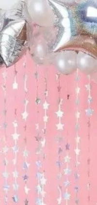 This stunning phone live wallpaper features a colorful bunch of balloons swaying gently in the breeze on a decorated table