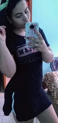This lively phone live wallpaper showcases a fit woman taking a mirror selfie while wearing a t-shirt and black leggings