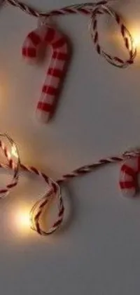 This phone live wallpaper features a close-up of a beautiful string of lights decorated with candy canes