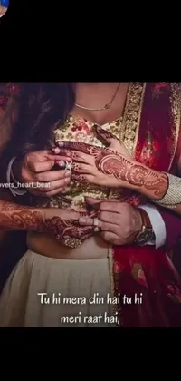 This phone live wallpaper depicts intricate henna designs on someone's hands with a lovely couple dressed in traditional Indian attire, surrounded by incoherent text in Hindi