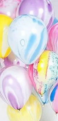 Add a playful touch to your phone with this cute and whimsical live wallpaper featuring a colorful bunch of balloons on a table
