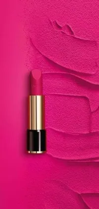 This phone live wallpaper showcases a lipstick in a stunning hot pink shade against a pretty pink background