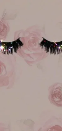 This phone wallpaper features a stunning image of black frilled eyelashes with shimmering iridescent beads, sparkling petals, and exquisite black opals