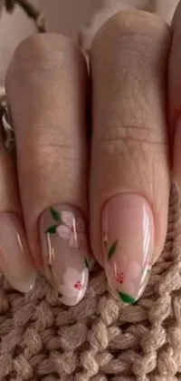 This stunning phone live wallpaper showcases a photorealistic painting of delicate flowers resting on human nails