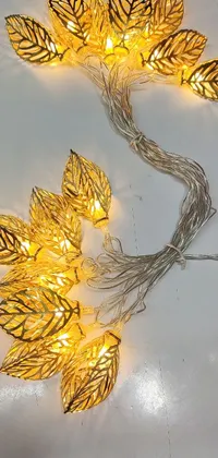 This live wallpaper showcases a close-up image of string lights on a table, framed by an intricate Art Nouveau engraving with golden leaves